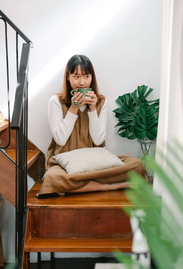 Lady sitting on stairs and drinking tea
